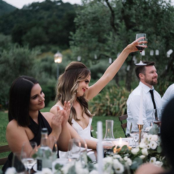 在招待会吐司期间，在接待期间举起一杯葡萄酒的新娘