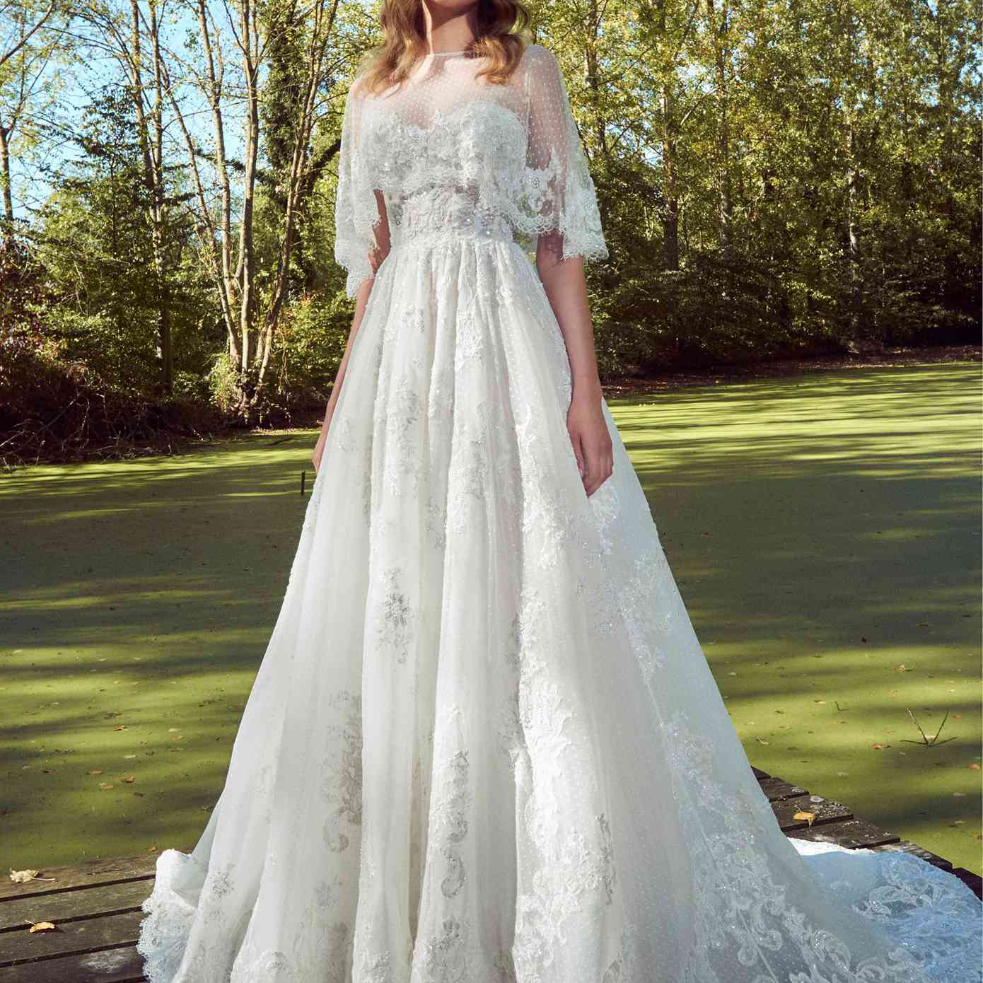 模型在无肩带甜心点缀薄纱礼服公主串珠花边刺绣和虚线薄纱莱与睫毛花边小披肩