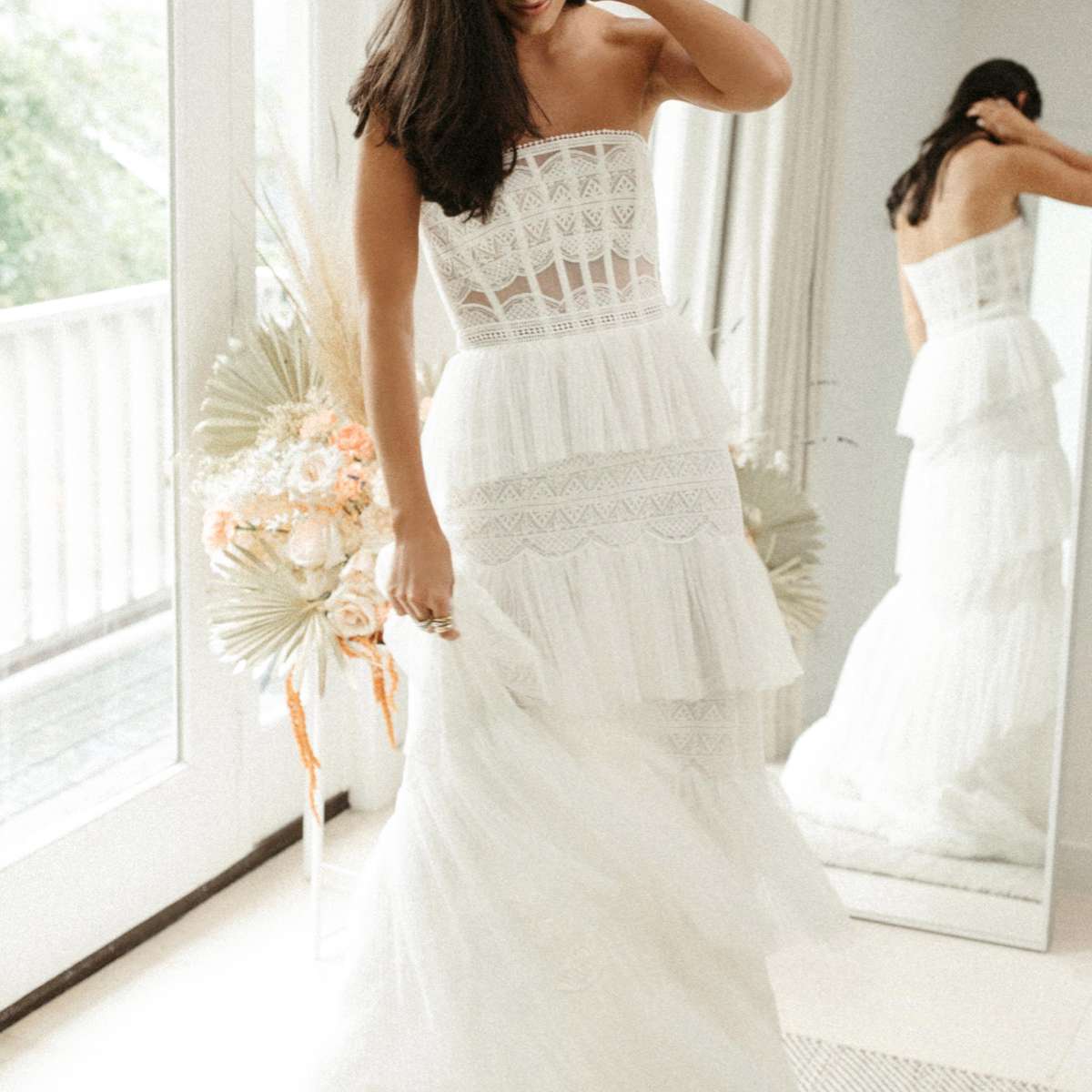 模特在无肩带边界蕾丝礼服与褶皱网层