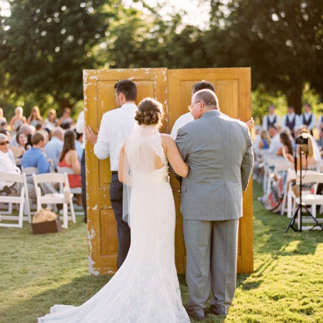 新娘和父亲准备走木头门背后的通道