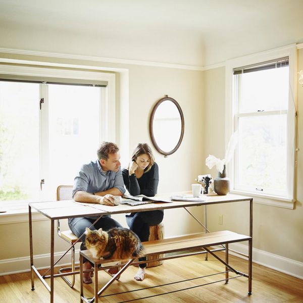 在桌上的夫妇一起读报纸“class=