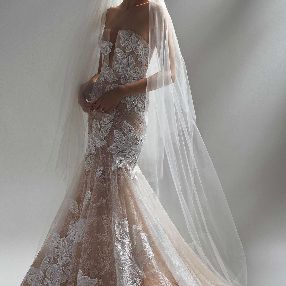 模特在薄纱合身和闪光的婚礼礼服与花卉剪纸