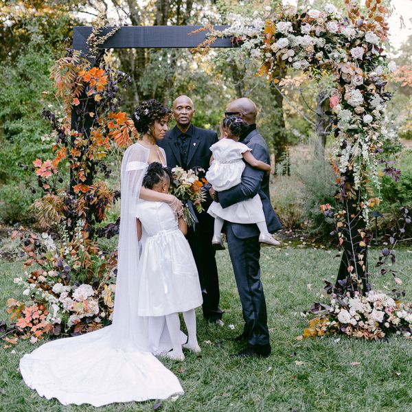 新娘和新郎带着两个女儿在圣坛上