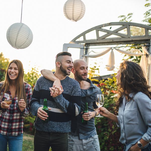 两个订婚的男人在户外聚会上与客人交谈