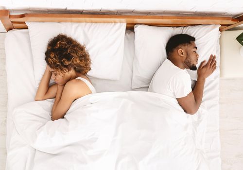 couple sleeping on opposite sides of bed