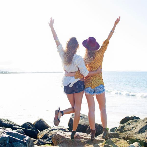 两个女孩由海洋举起双臂