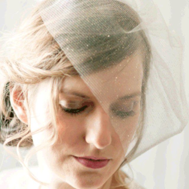 金发新娘戴着闪闪发光的金色薄纱鸟笼面纱