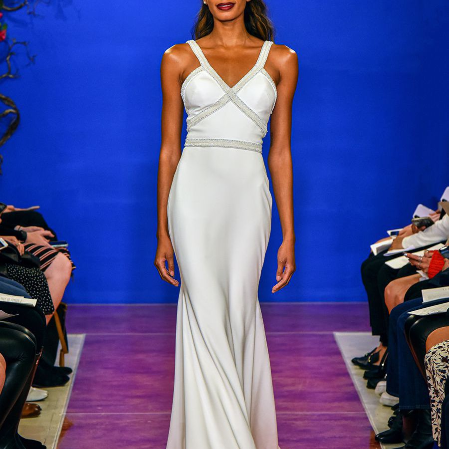 模特穿着v领绉纱美人鱼裙，带着珠宝项链走下t台