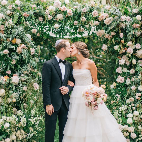 新娘和新郎在花拱下接吻