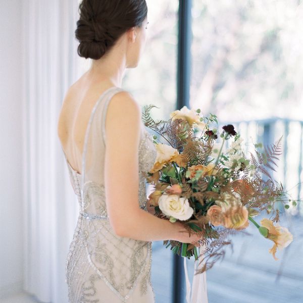 新娘穿着复古的婚纱牵着她的花束