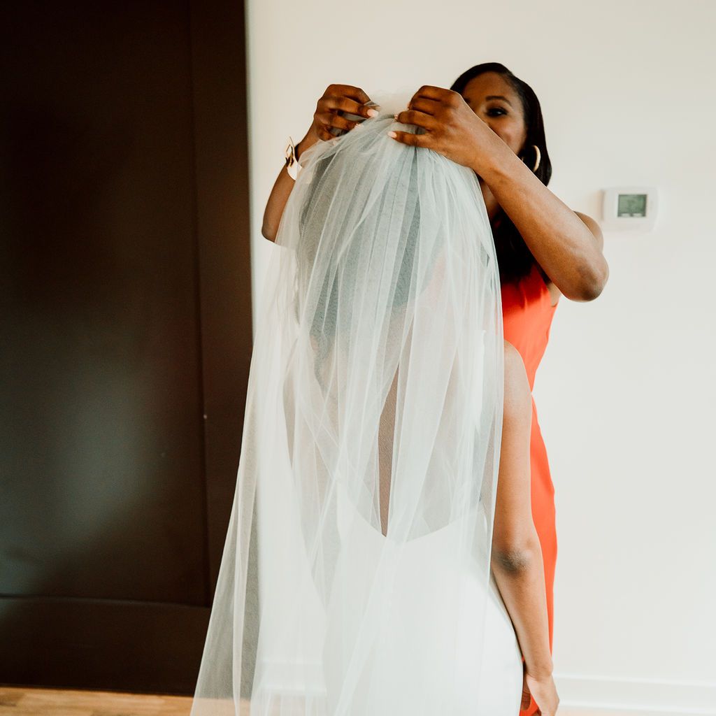 新娘的母亲帮她戴上面纱。