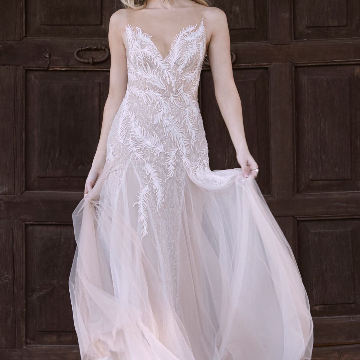 模特穿着一件v领羽毛刺绣的薄纱礼服