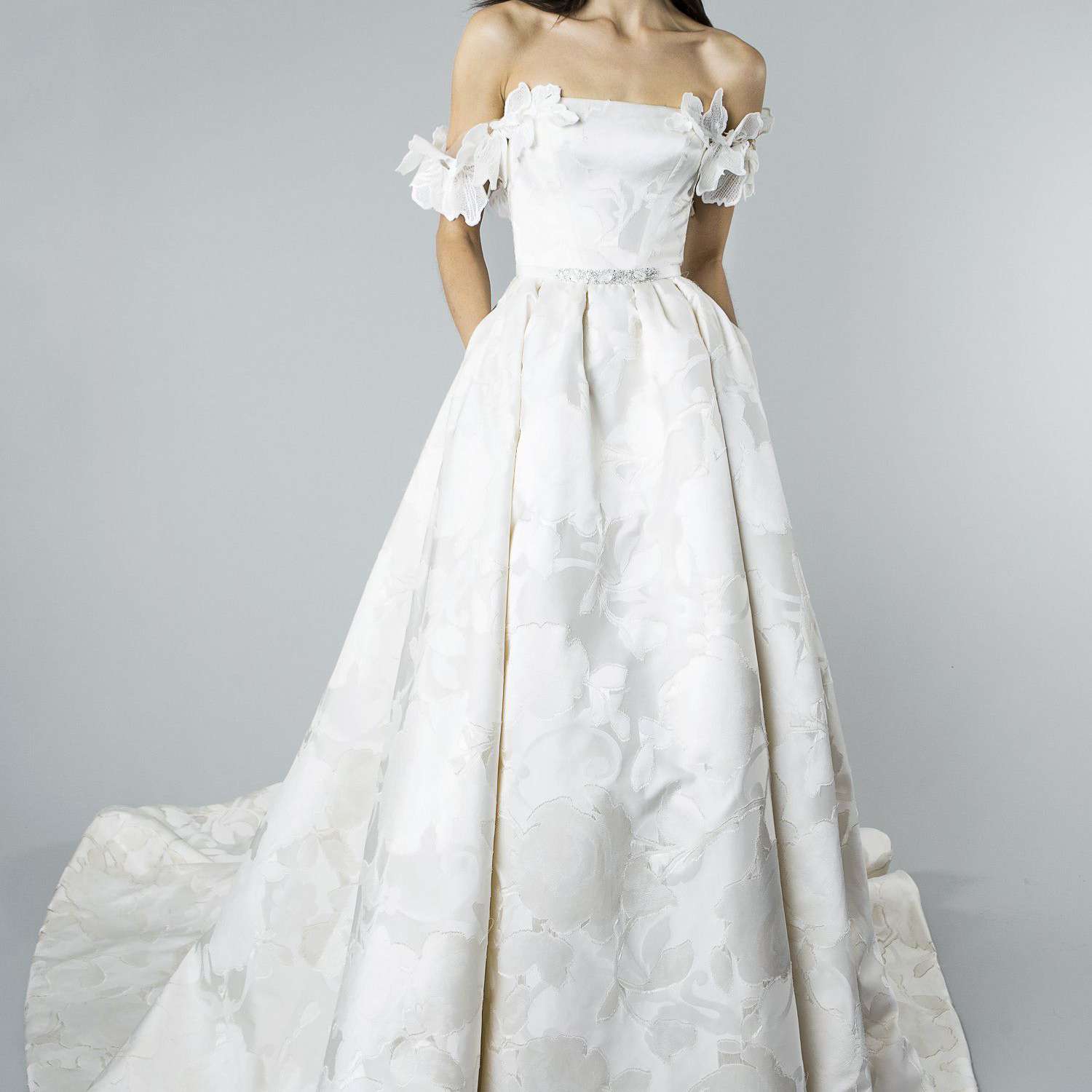 模特儿在象牙丝Fils Coupe玫瑰主题舞会礼服与花卉垂帘帽袖