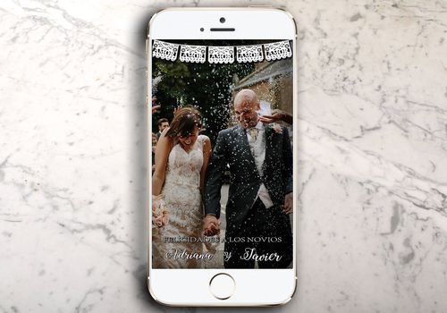 在大理石柜台上面的iphone与婚礼照片和geofilter在snapchat