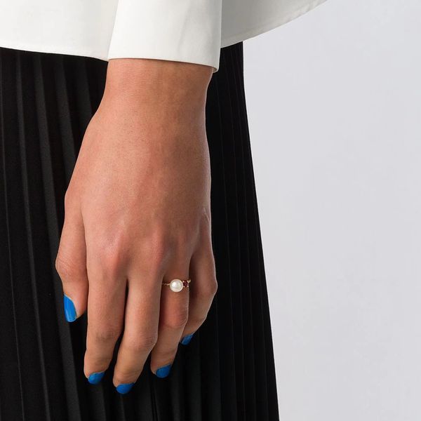 手上涂着蓝色指甲油，戴着珍珠戒指
