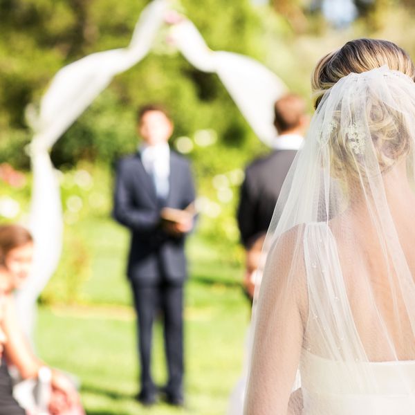 后面的新娘戴着面纱走过过道