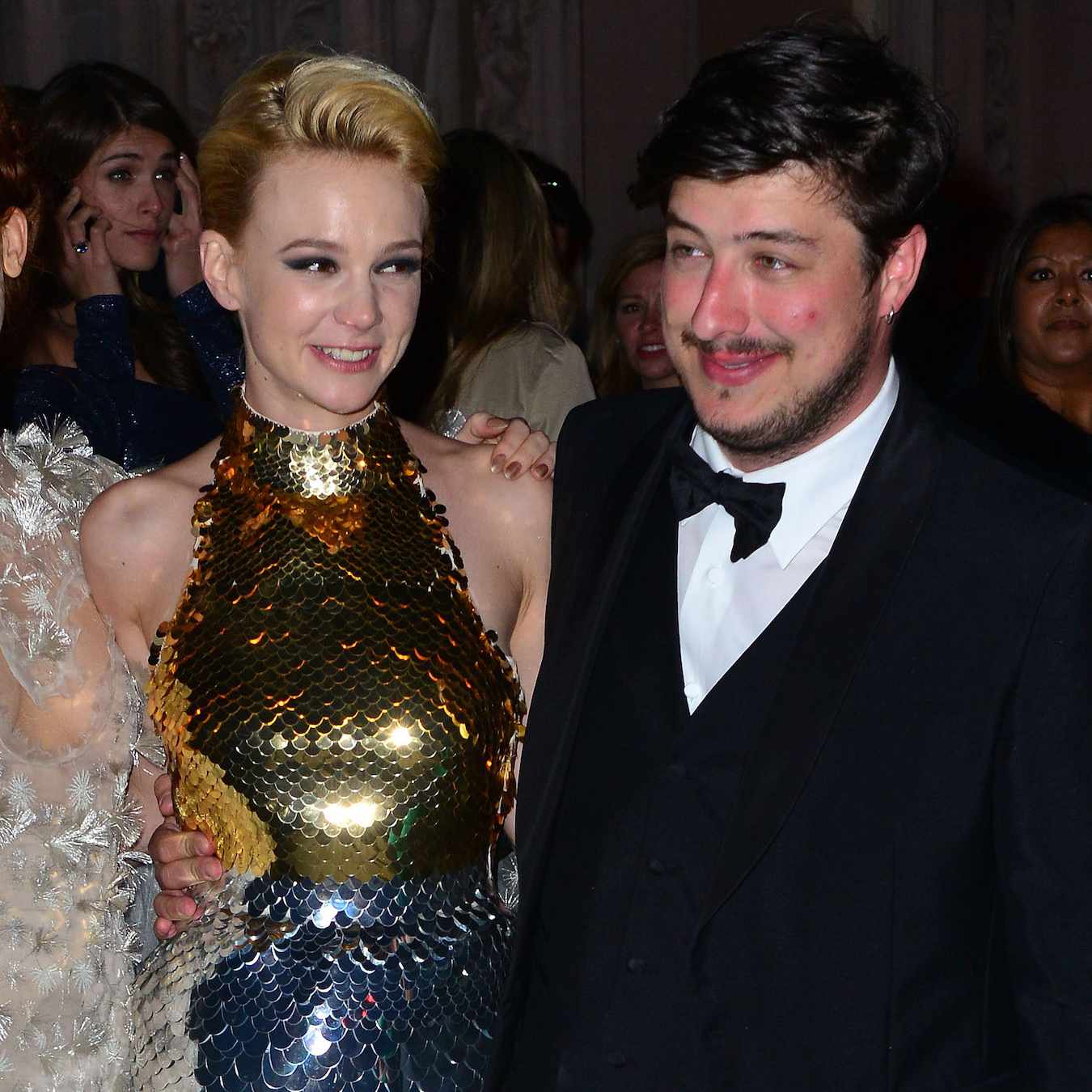 Mumford & Sons乐队的歌手Marcus Mumfort挽着妻子、女演员Carey Mulligan的手，后者穿着迷人的亮片，梳着光滑的后发。