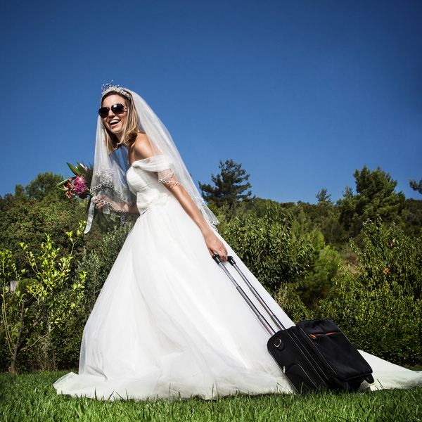 新娘穿着婚纱拖着行李箱