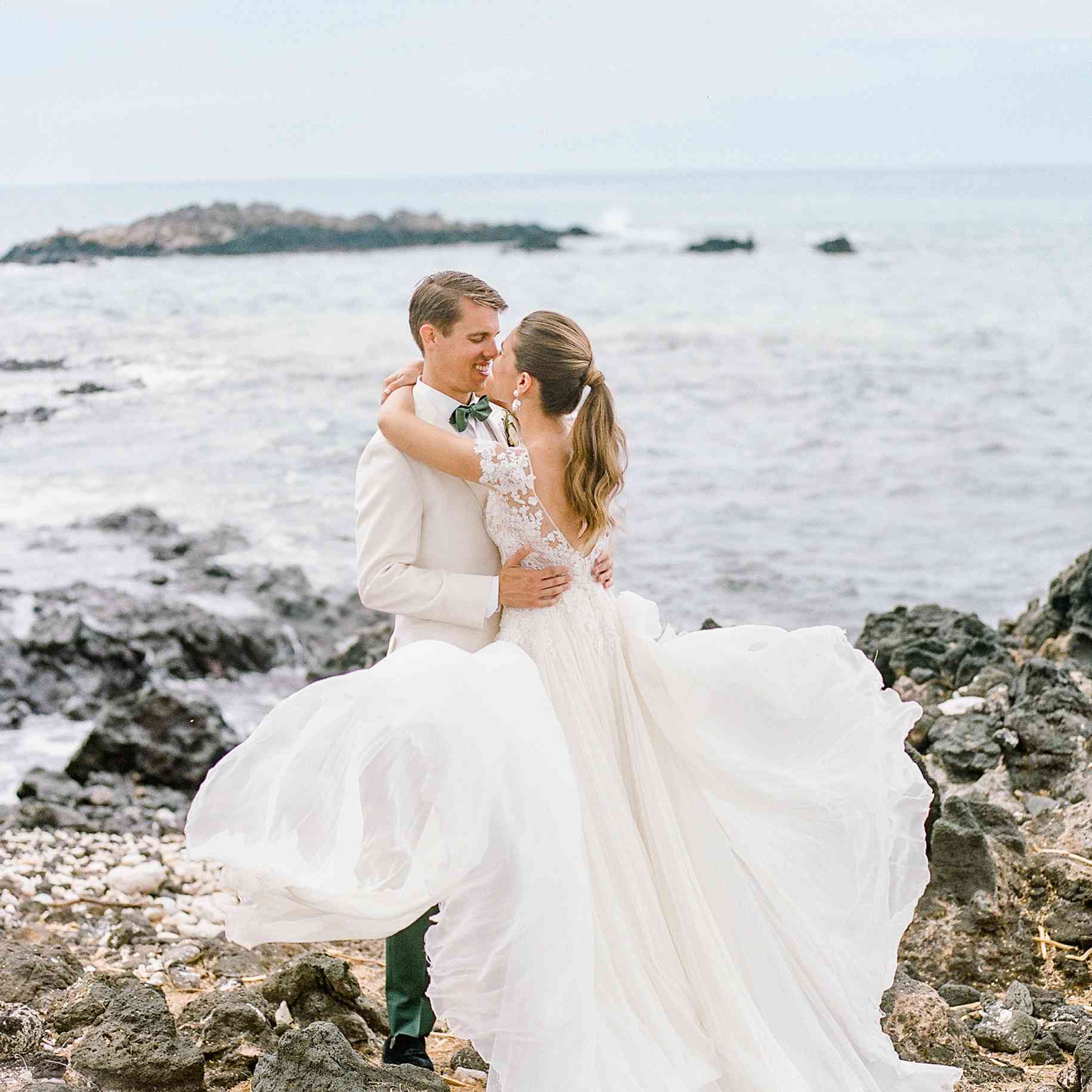 新郎和新娘站在岩石海滩上