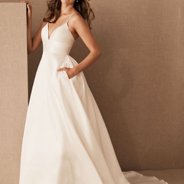 Model in thin-strap white wedding gown with pockets