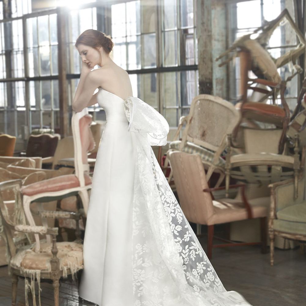 模特穿着无肩带的a字婚纱，背后有超大的花边蝴蝶结