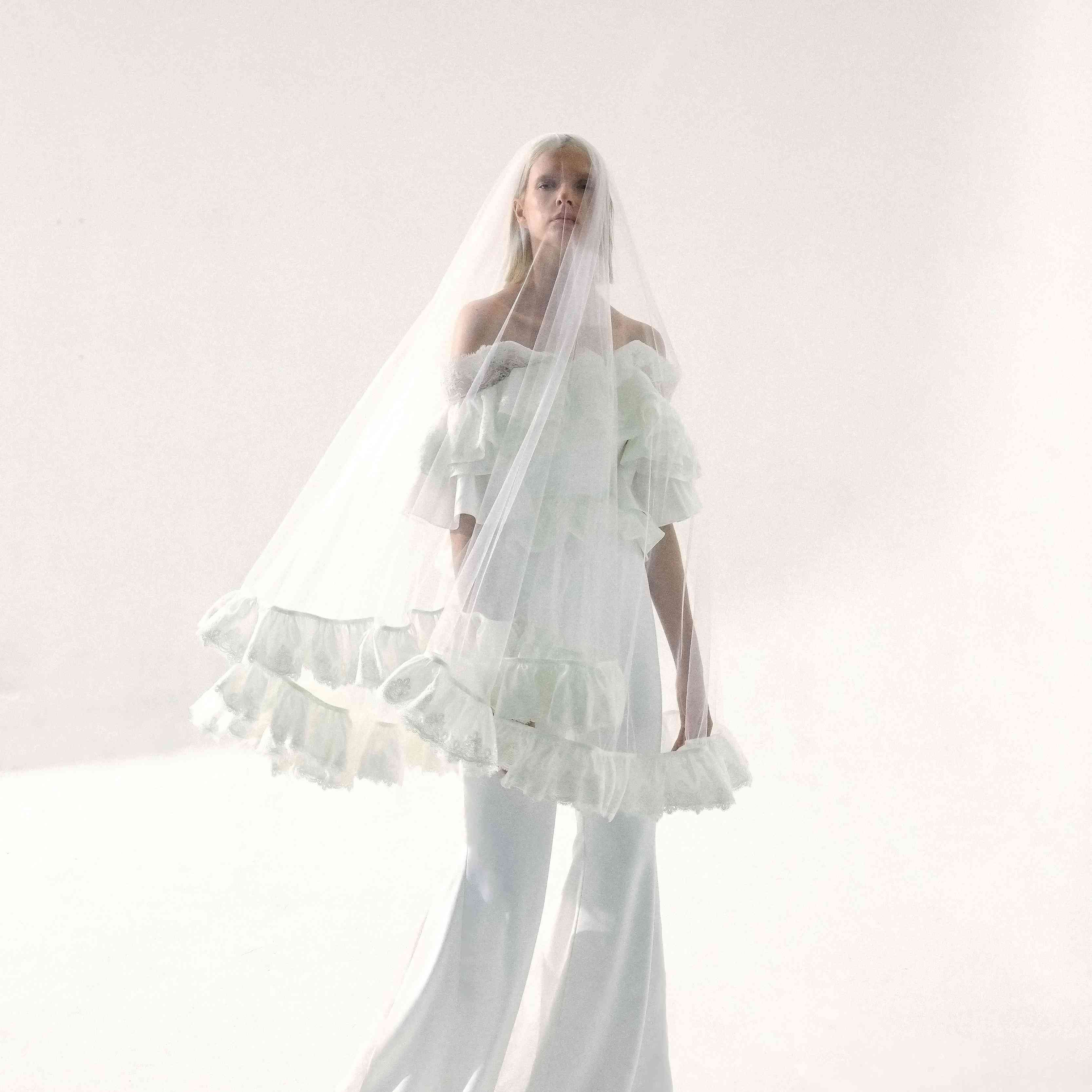 在竖起顶级模特和阔腿裤与下摆竖起手指长面纱