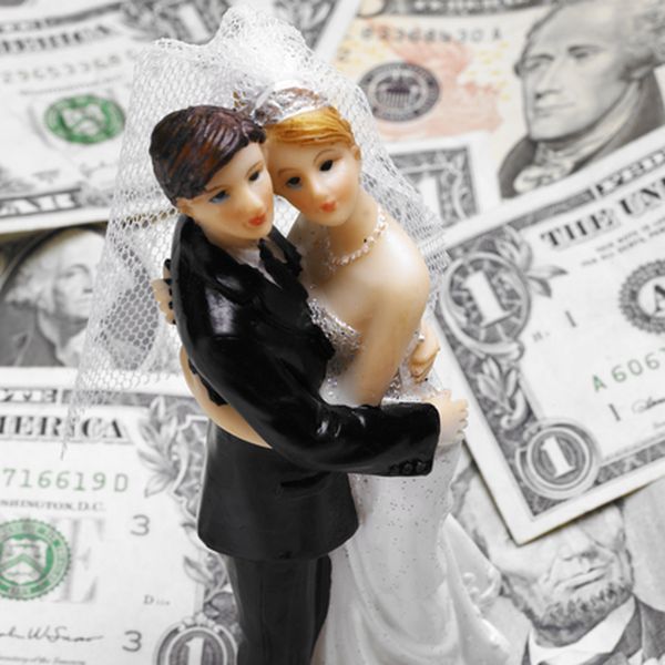 新娘和新郎的蛋糕顶部放在一堆美钞上