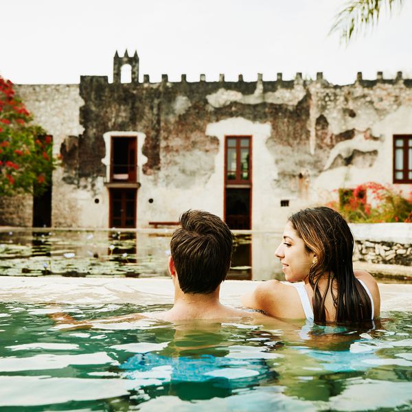 一对夫妇在游泳池里一个女人看着一个男人，那个男人在看她