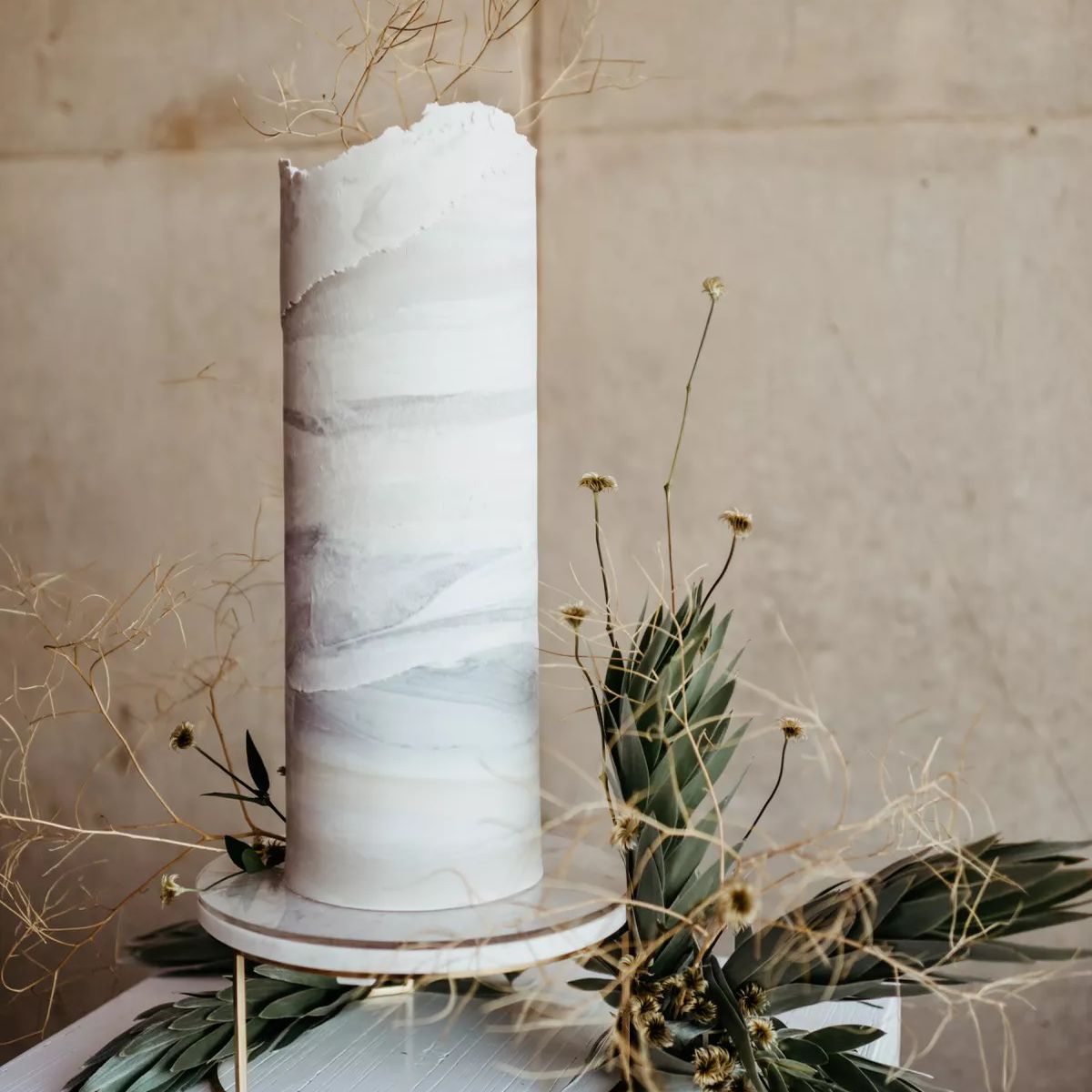 有绿色植物的高大婚礼蛋糕