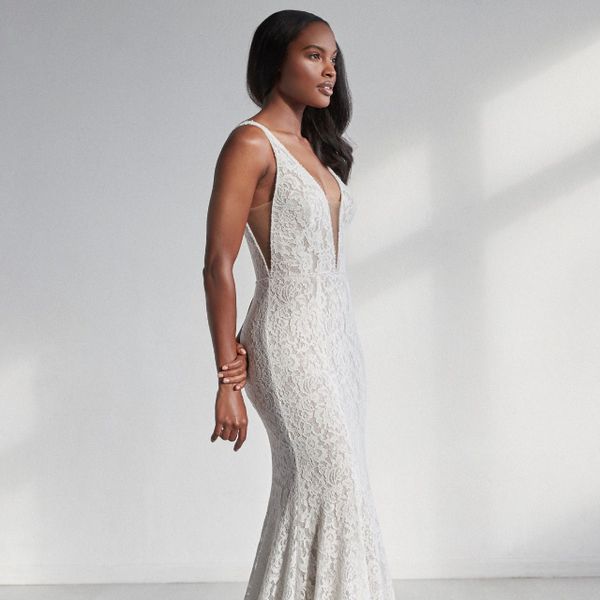 模型在Allover蕾丝美人鱼礼服，陷入困境V领带和幻影镂空侧