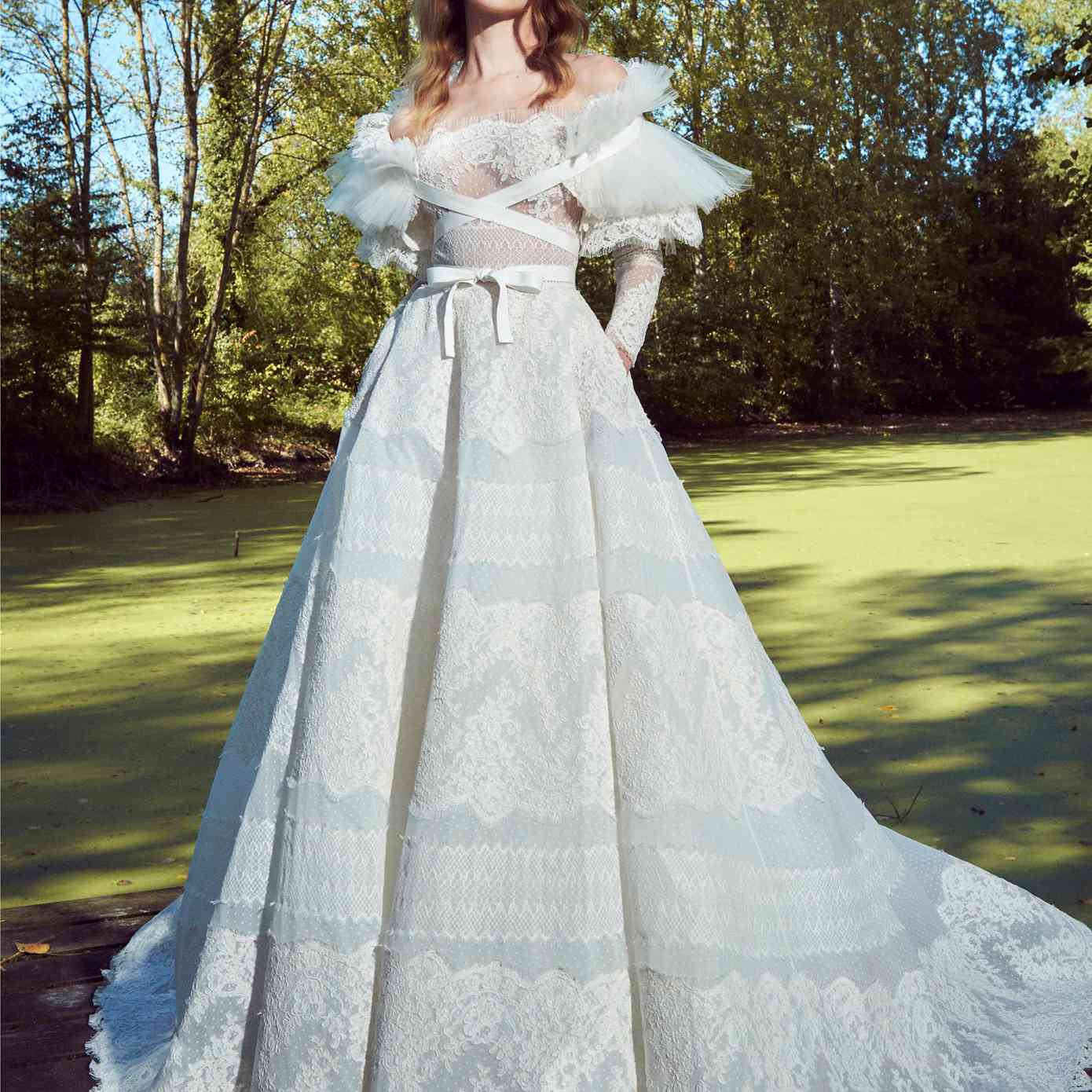 模型露肩长袖点缀薄纱与褶薄纱花边刺绣,花边舞会礼服大衣与纵横交错的丝带