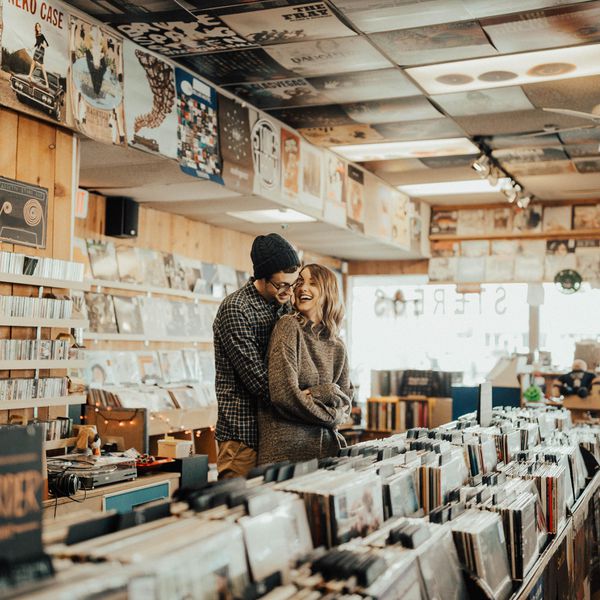 男人和女人在唱片店的拥抱“class=