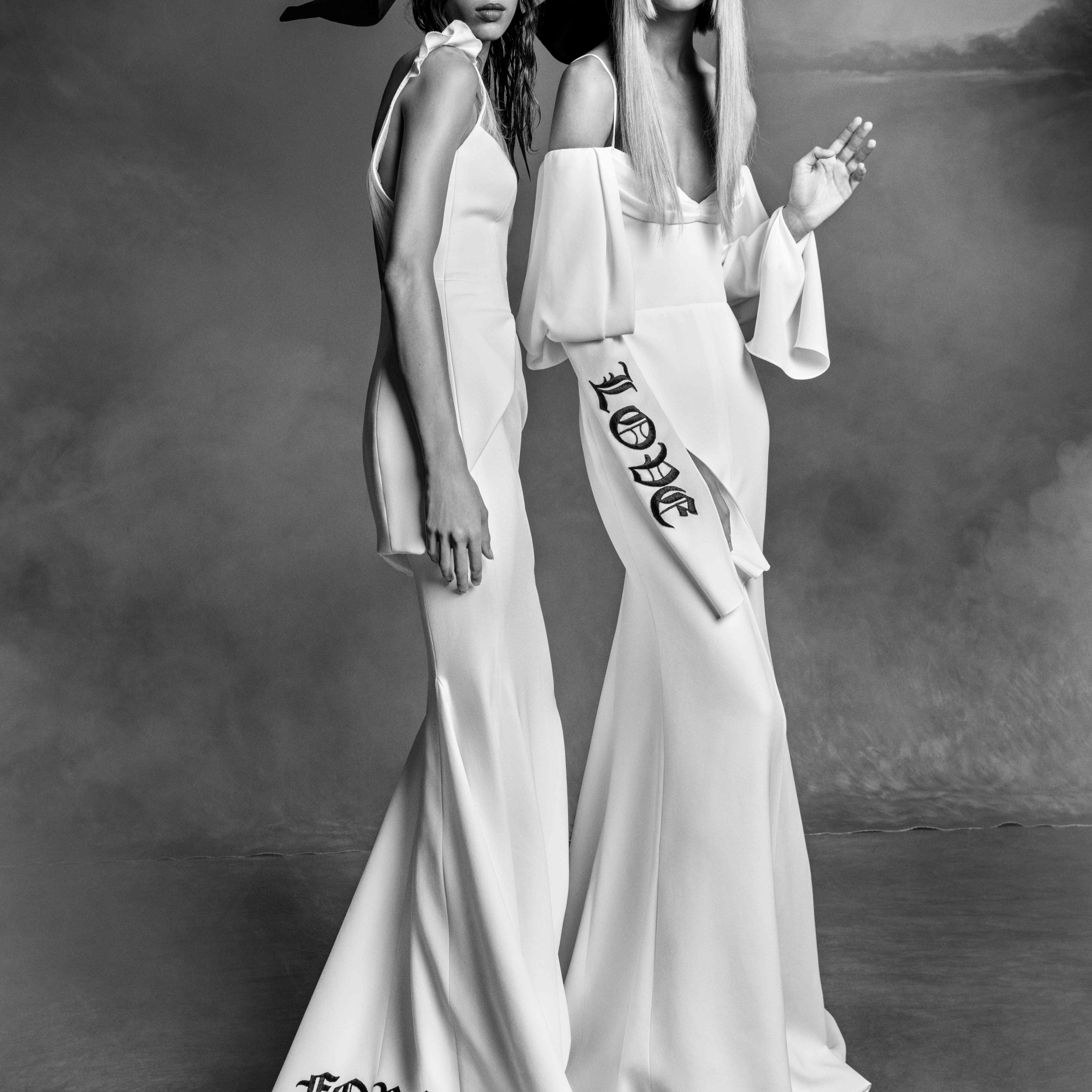 两个身穿白色婚纱的模特，左边的裙子上绣着“永远”字样，右边的袖子上绣着“爱”字样