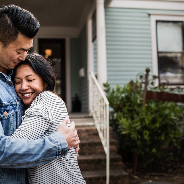 年轻夫妇画象在家前面的“class=