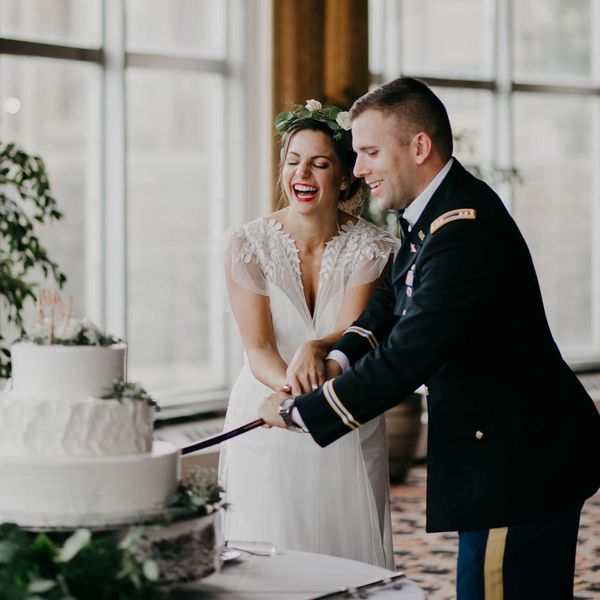 新娘和军人新郎用军刀切蛋糕