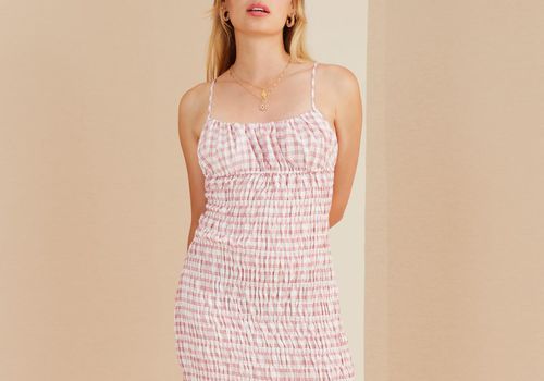 女人穿着粉白格子衣服。