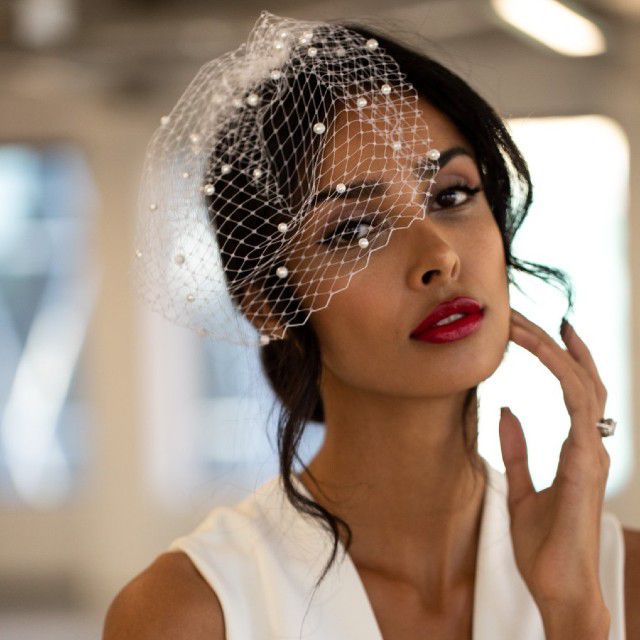 穿红色唇膏和珍珠缀饰鸟笼面纱的新娘