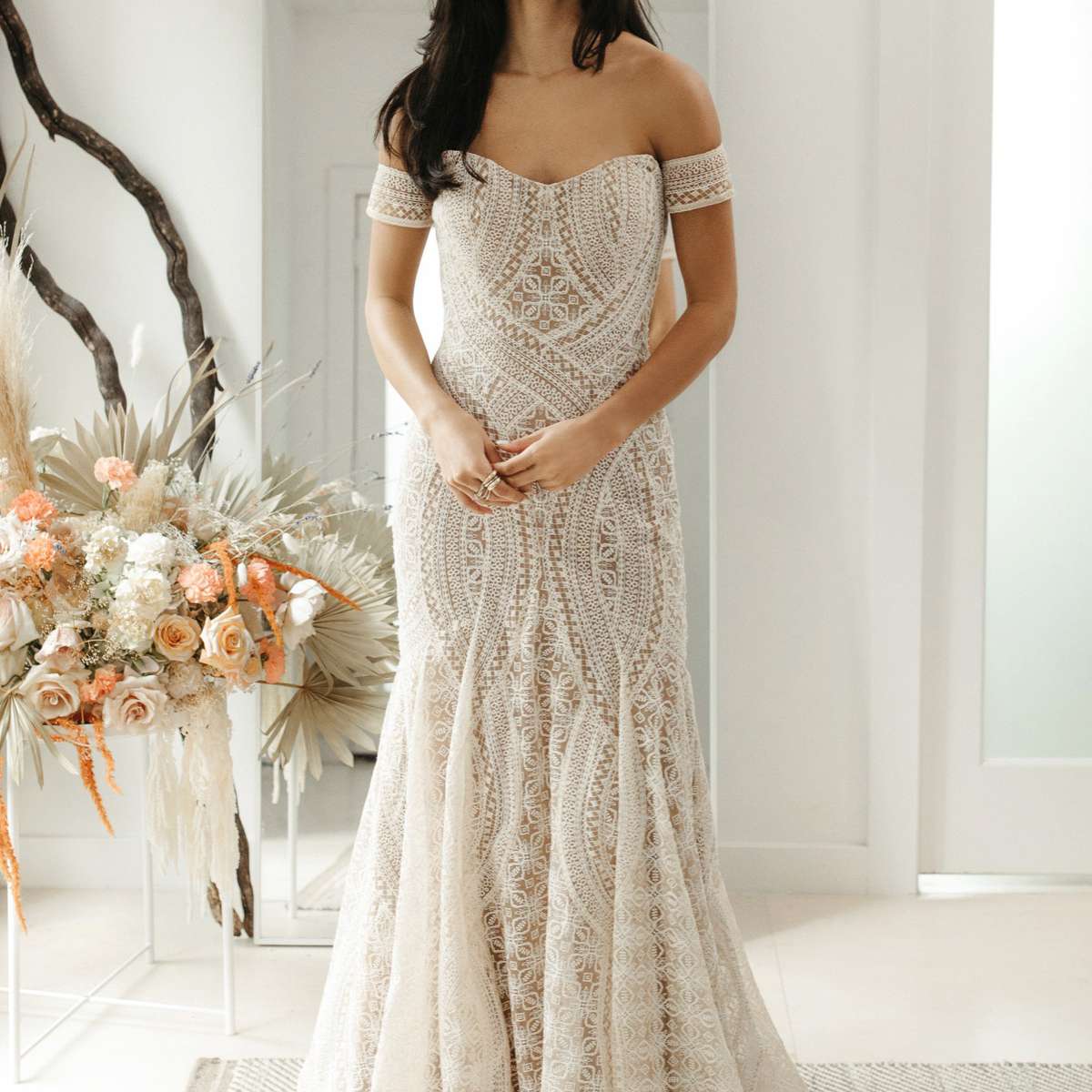 模特在无肩带的fit-and-flare刺绣礼服与配套的臂章