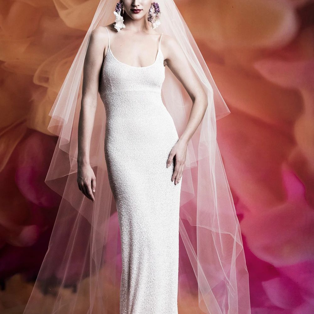 模特穿着合身的薄肩带闪亮的露领礼服