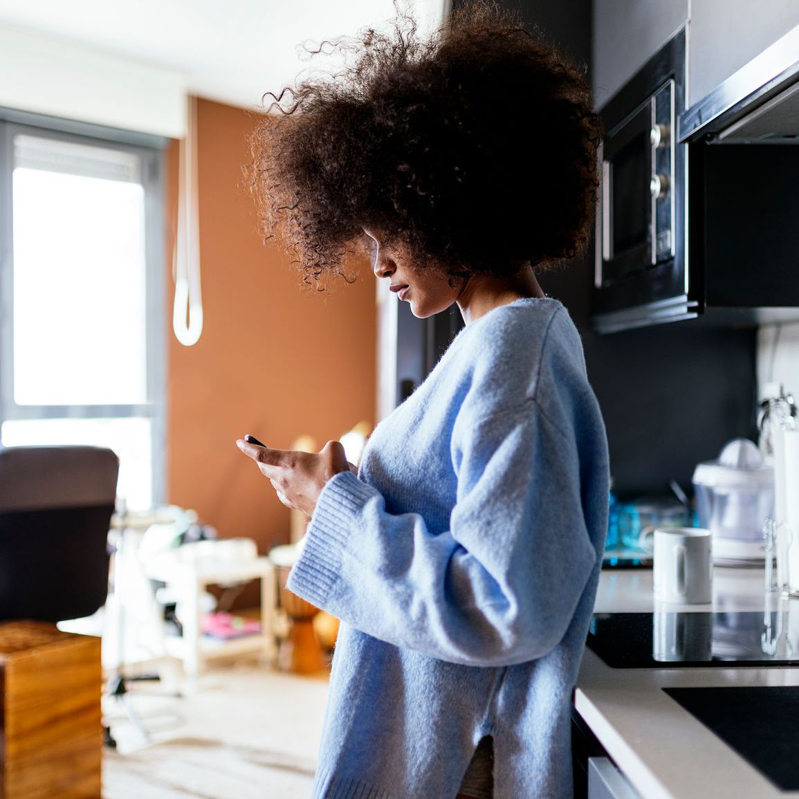 一个女人在厨房发短信