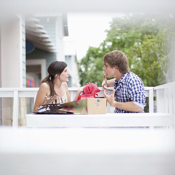 年轻已婚夫妇争论关于财务的财务在阳台上“class=