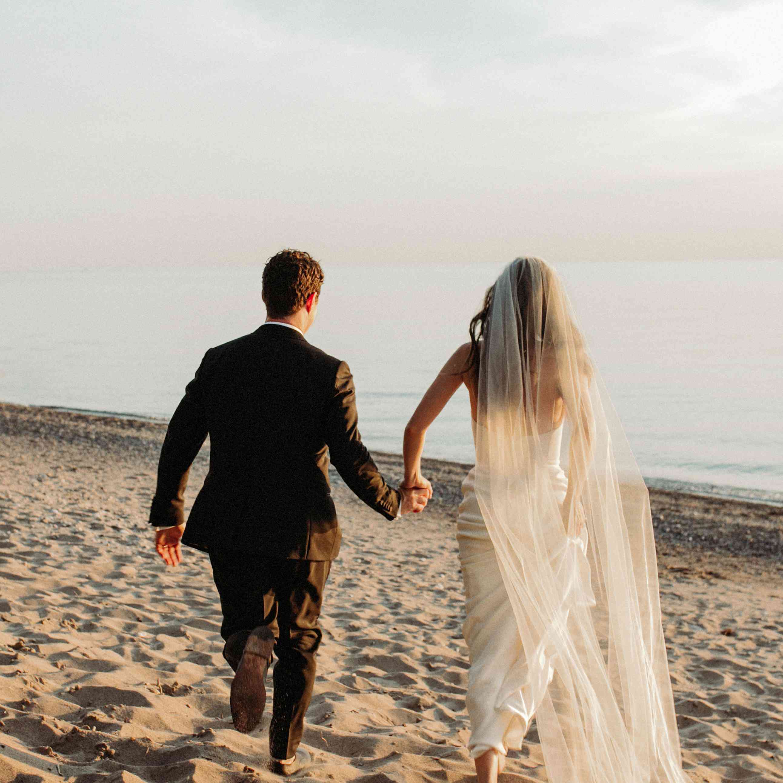 新郎和新娘在沙滩上跑步