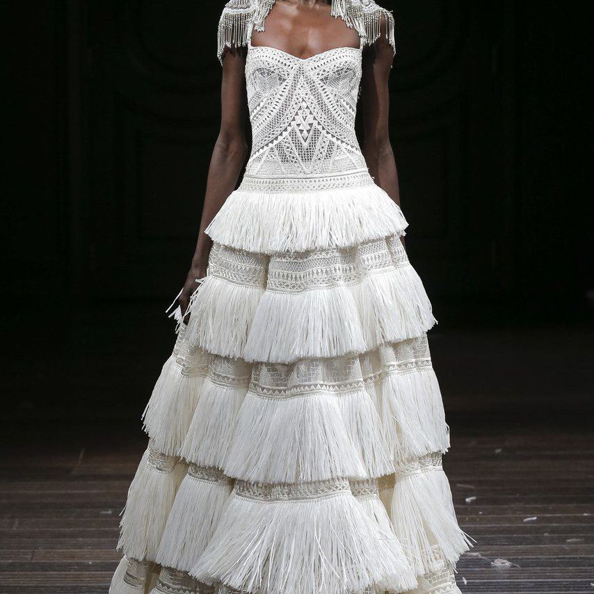 模特在刺绣长袍与椰叶细节和流苏裙