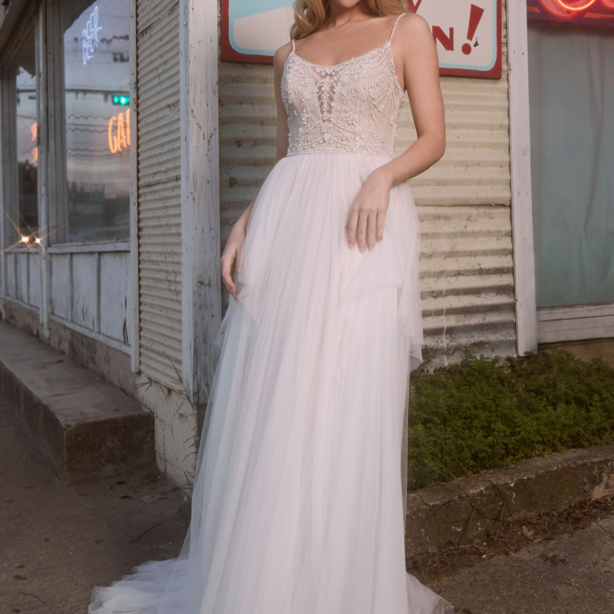 模特穿着露脐领口的a字长裙，配以珠饰紧身胸衣和柔软的网眼裙