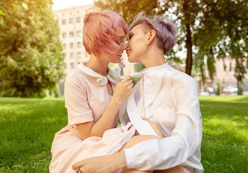女同性恋夫妇在公园接吻的侧视图。