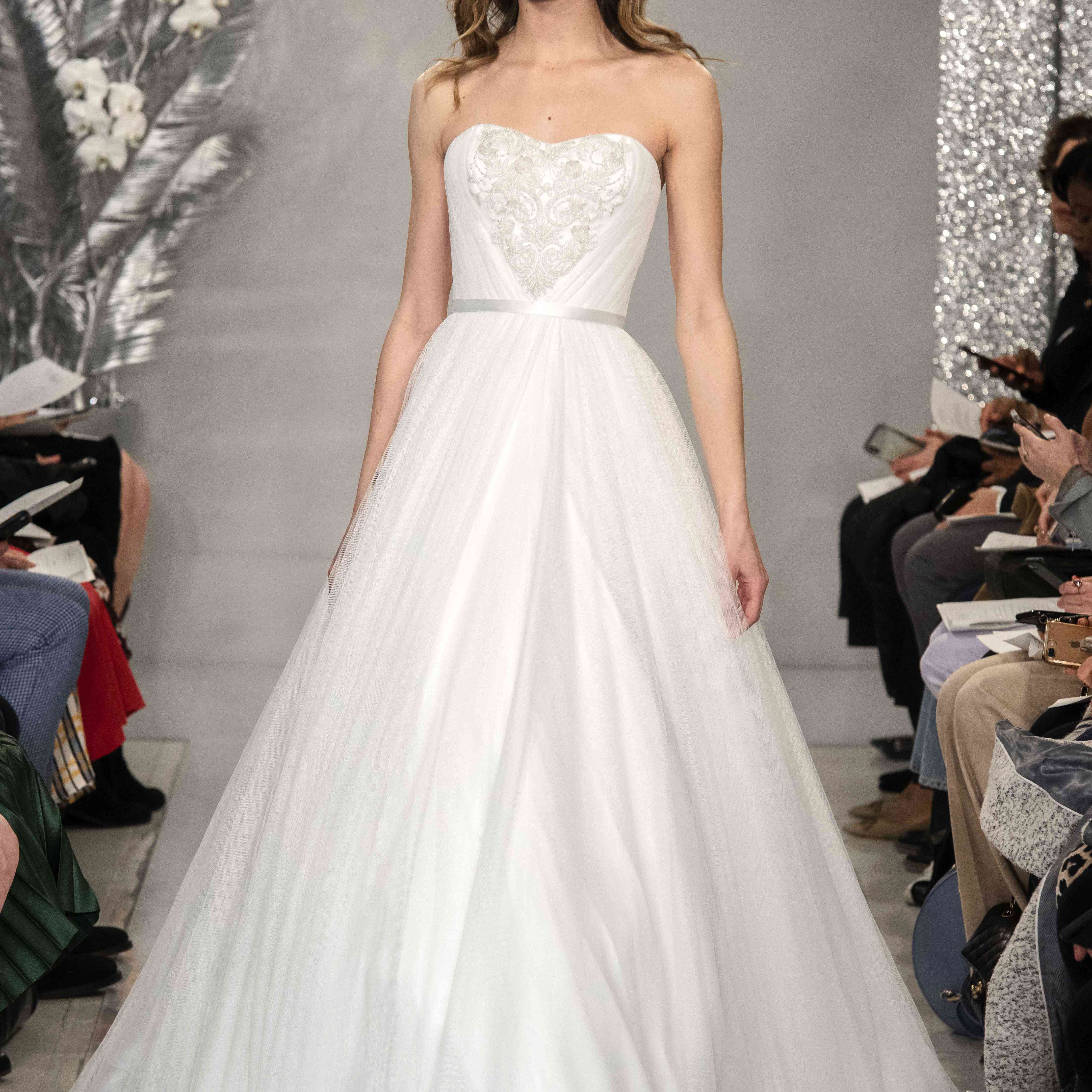 跑道的模型在无肩带薄丝的裙子与绣胸衣