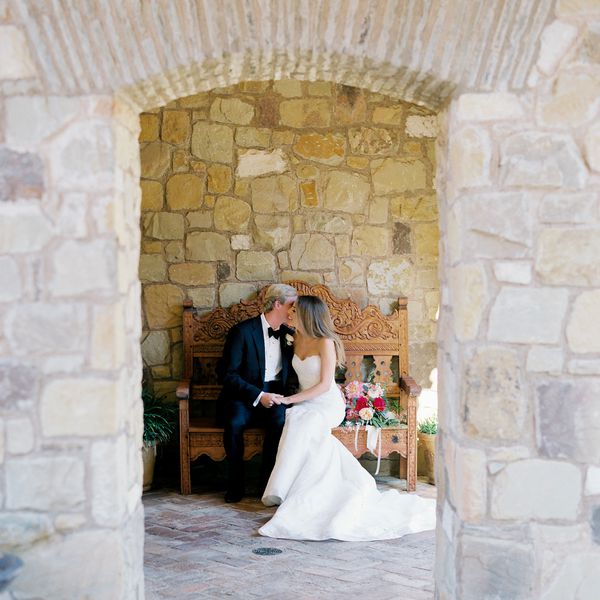 新郎和新娘手牵着手坐在长凳上