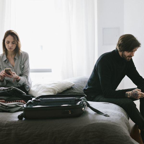 一对夫妇拿着箱子坐在床上