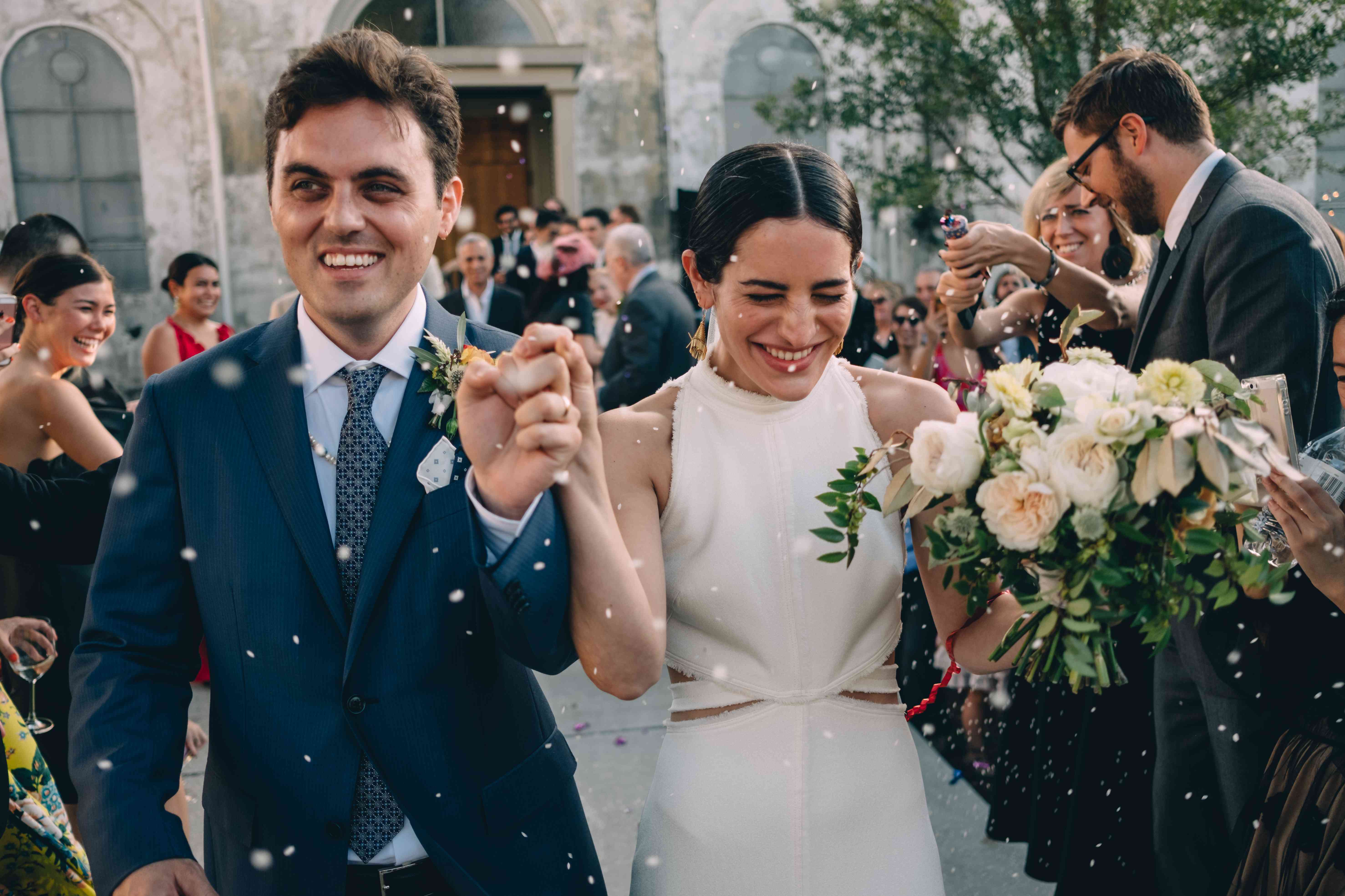 新郎身着蓝色燕尾服，新娘身着露腰礼服离开婚礼