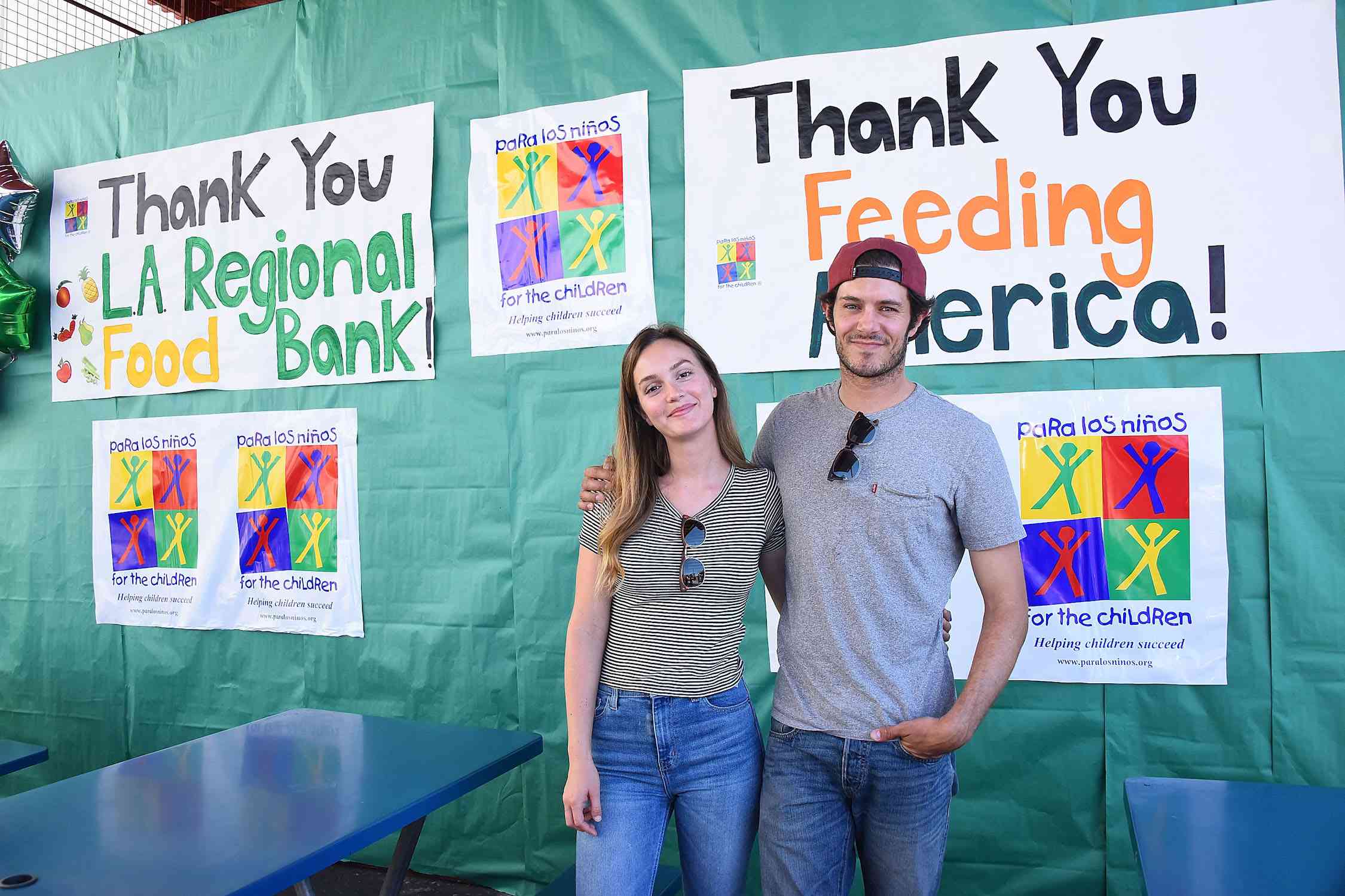 在“喂饱美国”的标志前，亚当·布罗迪搂着莉顿·梅斯特。